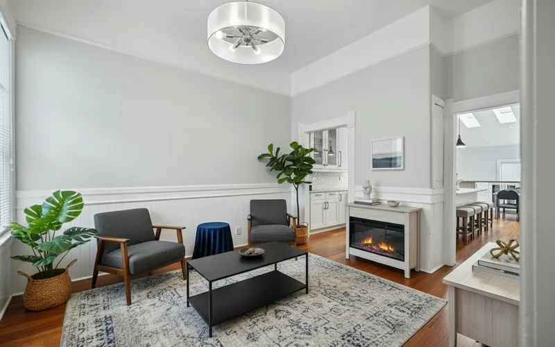 Add furnitures to this room, featuring a cozy, symmetrical layout centered around a black coffee table placed on a pattern...