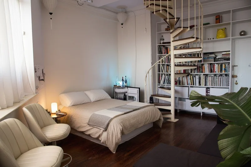 Clean up this bedroom for a real estate listing. Remove: personal photos, clutter on nightstands, clothes, excessive decor...